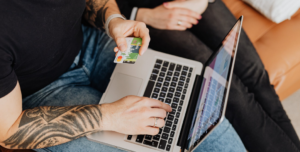 man holding laptop and credit card